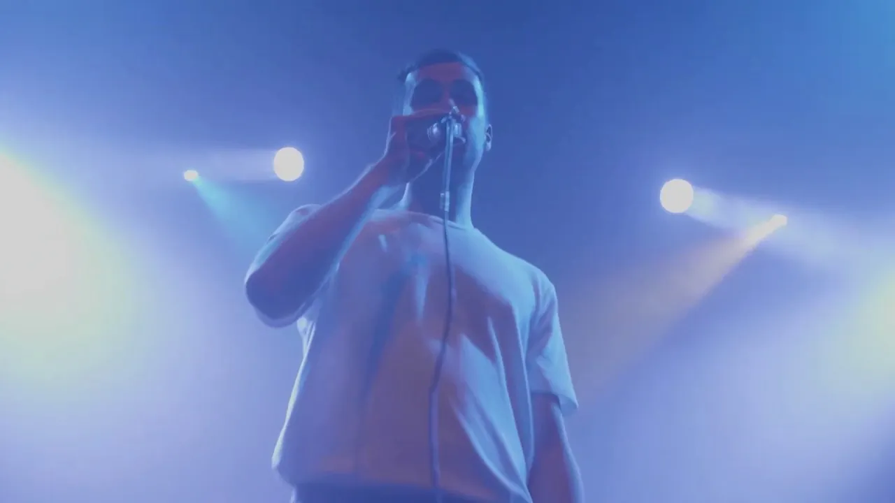 Emil Kampp synger under blå scenelys i Amager Bio